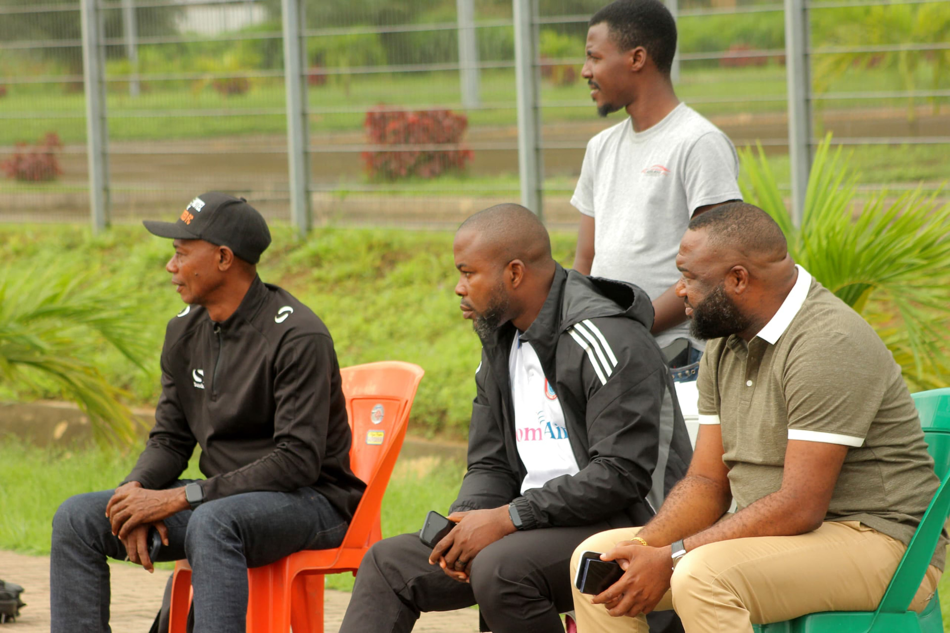 Camp Gee Football Academy coaching staff observing a training session from the touchline