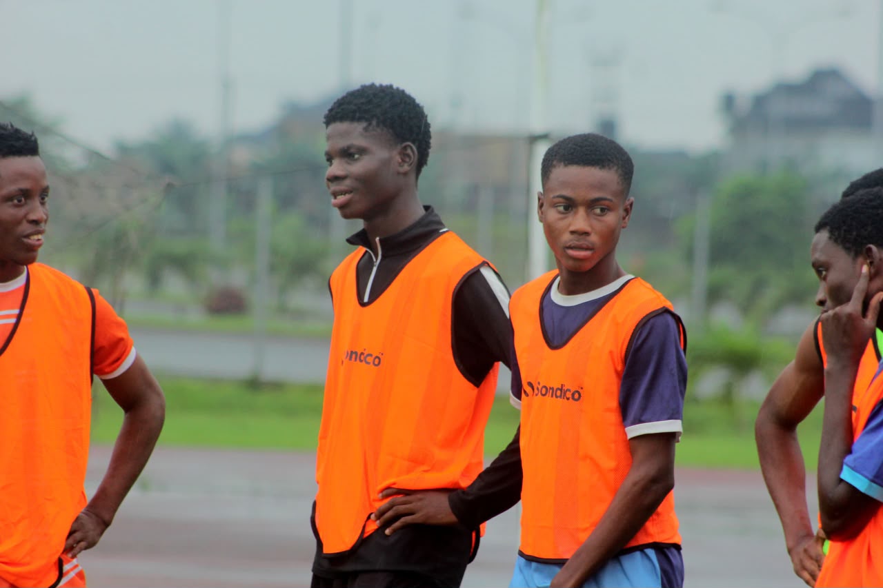 Players in orange bibs listening to instructions during a free Camp Gee Football Academy trial